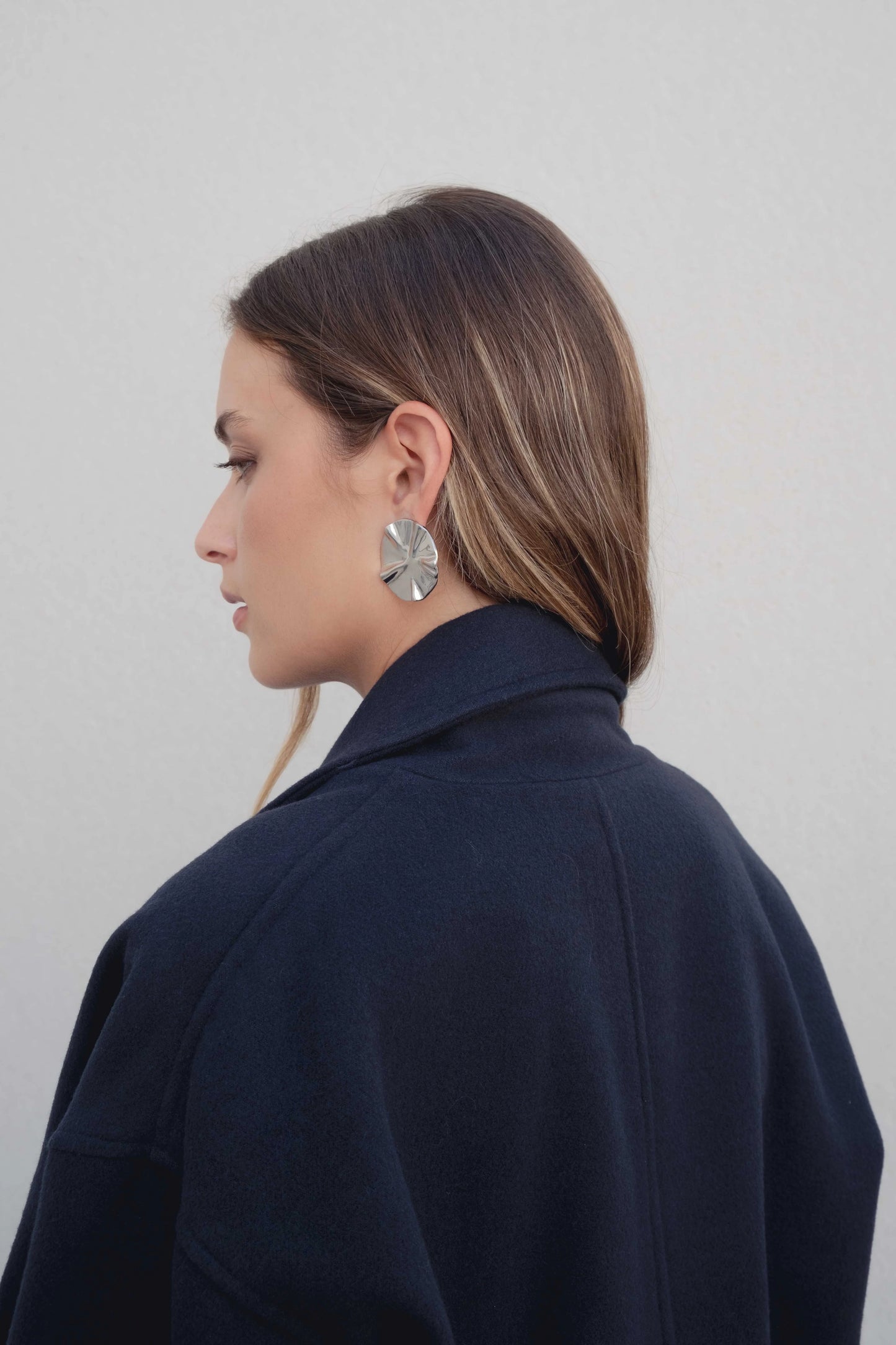 Vista lateral del abrigo corto marino con hombro relajado y cuello envolvente, estilo actual – Zenda Couture