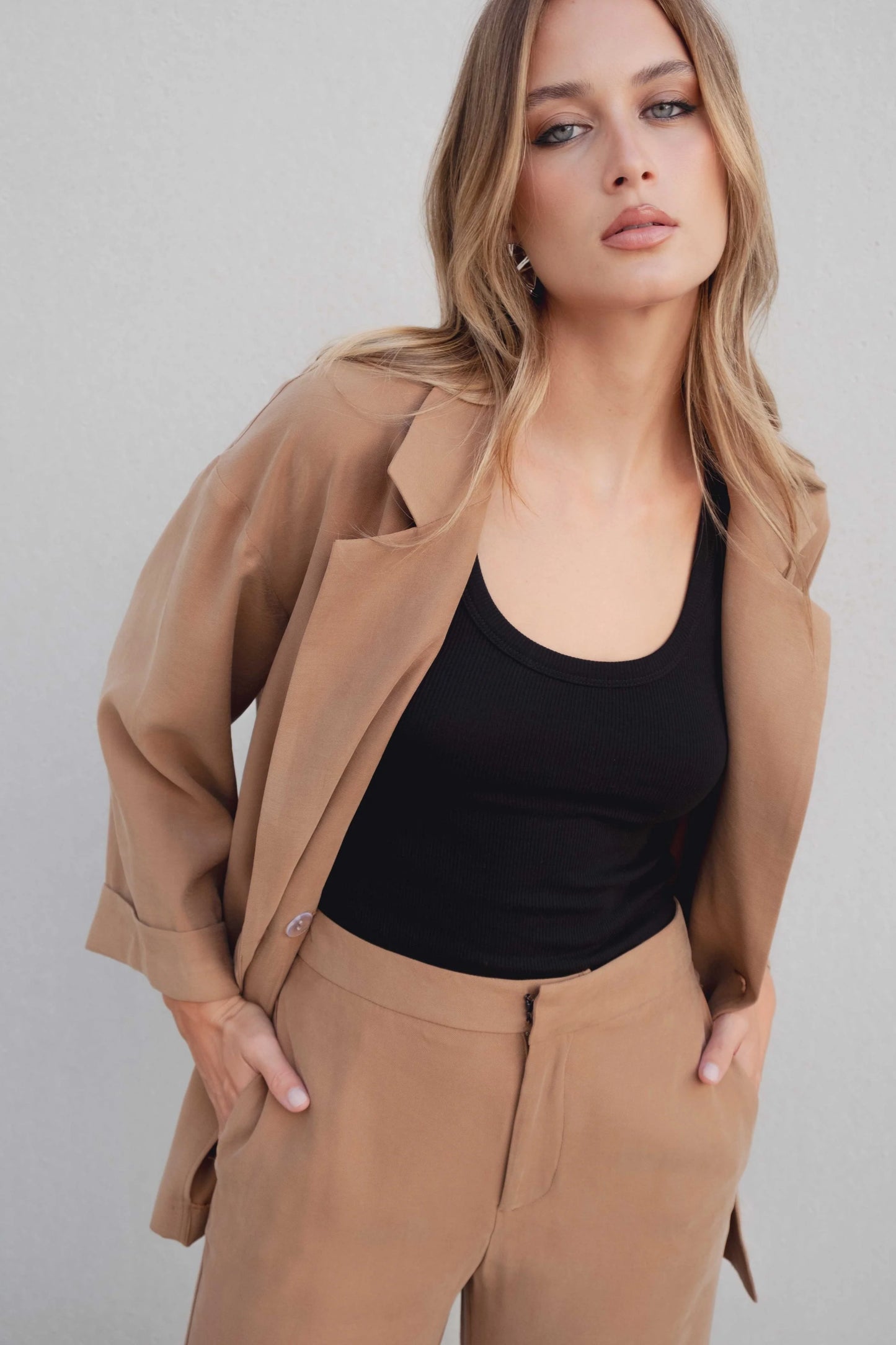 Detalle de solapa clásica y escote en blazer oversize cruzada color camel, acabado pulido – Zenda Couture
