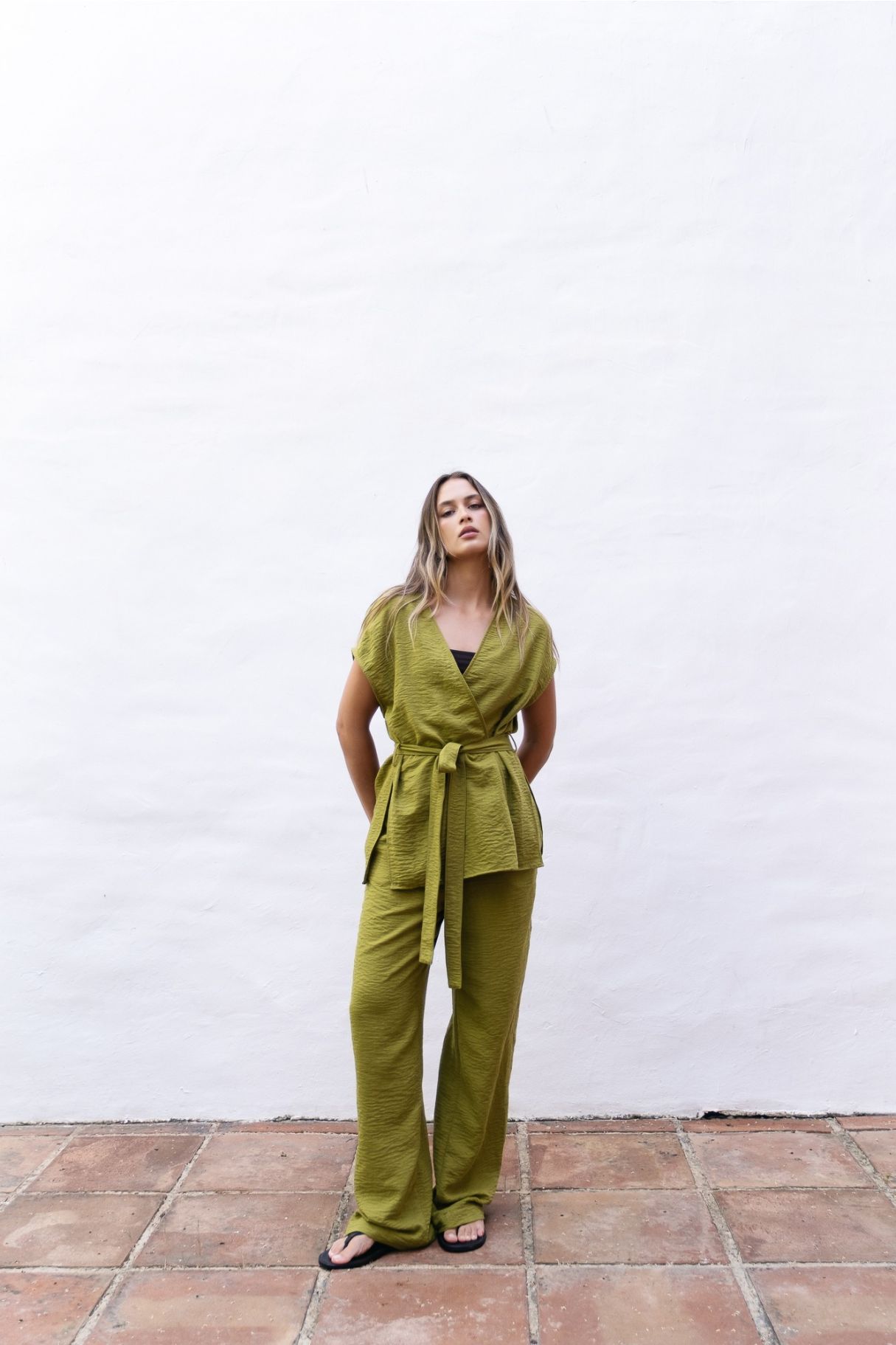 Modelo con pantalón fluido verde combinado con top negro Zenda Couture