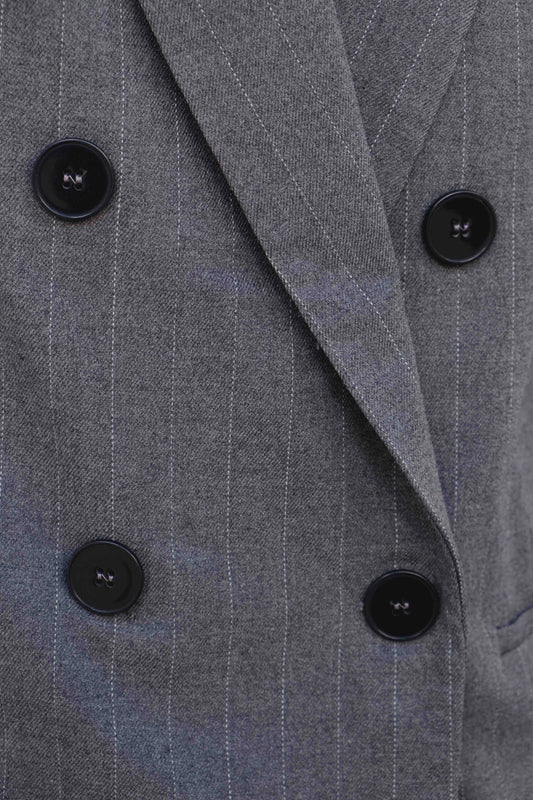 Primer plano de doble botonadura y solapa en blazer raya diplomática gris, acabado sastre – Zenda Couture