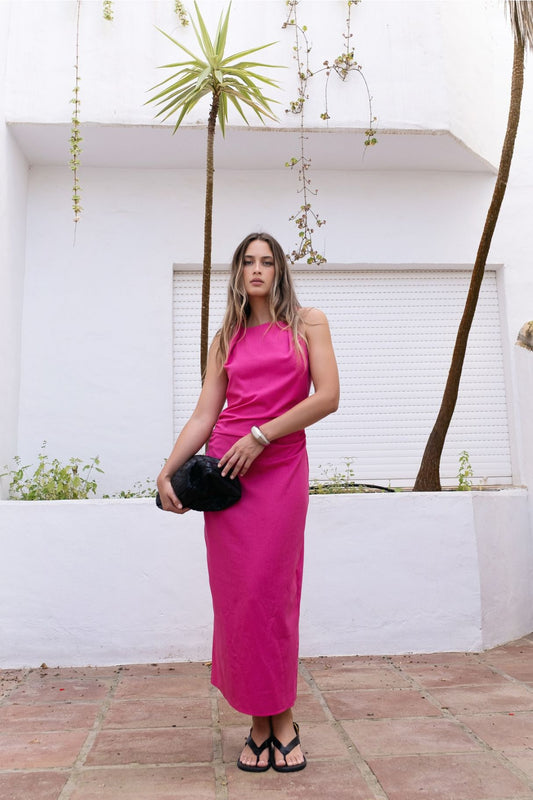 modelo con vestido midi fucsia de lino escote recto posando de pie